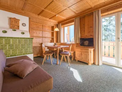 a bedroom with a bed and a table and a television at Apartment Wohnung in den Dolomiten mit traumhafter Aussicht by Interhome in Kastelruth