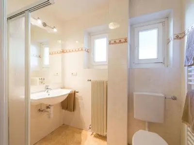 a bathroom with a sink and a toilet and a mirror at Apartment Wohnung in den Dolomiten mit traumhafter Aussicht by Interhome in Kastelruth