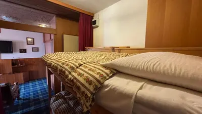 a bedroom with a bed with a bedspread on it at Apartment in the center of Cortina with private garage in Cortina dʼAmpezzo