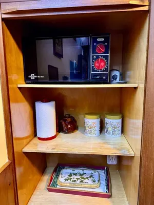 a shelf with a microwave and plates on it at Apartment in the center of Cortina with private garage in Cortina dʼAmpezzo