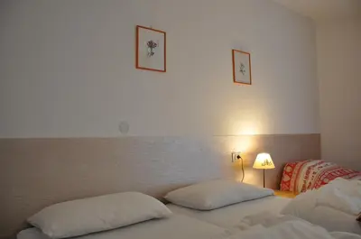 a bedroom with two beds with white pillows at El Ladinia Someda in Moena