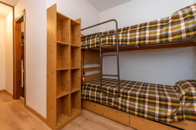 a bedroom with a bunk bed and wooden shelves at Petit Cirsio in Santa Fosca