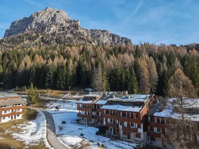 an apartment building in front of a mountain at Petit Cirsio in Santa Fosca