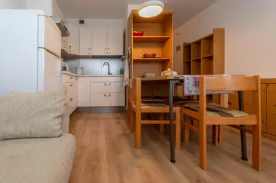 a small kitchen with a table and a dining room at Petit Cirsio in Santa Fosca