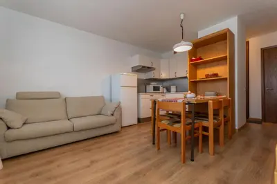a living room with a couch and a table and a kitchen at Petit Cirsio in Santa Fosca