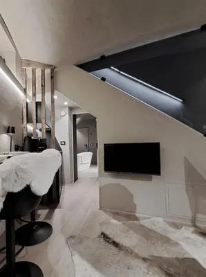 a living room with a tv on a wall at VHĀUS Apartment and Spa in Predazzo