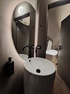a bathroom with a sink and a large mirror at VHĀUS Apartment and Spa in Predazzo