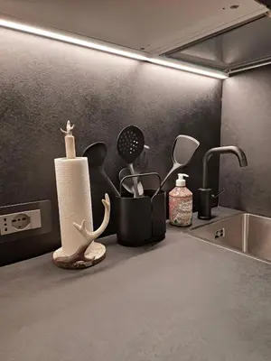 a kitchen counter with a sink and some utensils at VHĀUS Apartment and Spa in Predazzo