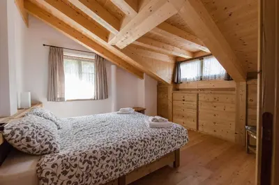 a bedroom with a bed in a room with wooden ceilings at Elegante Appartamento a Cortina in Cortina dʼAmpezzo