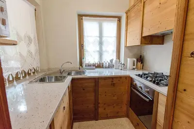 a kitchen with wooden cabinets and a sink and a window at Elegante Appartamento a Cortina in Cortina dʼAmpezzo