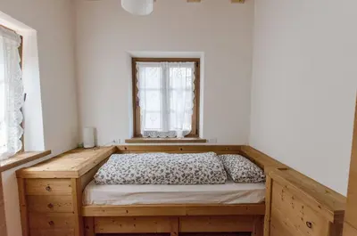 a bedroom with a wooden bed with a window at Elegante Appartamento a Cortina in Cortina dʼAmpezzo