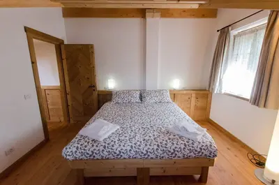 a bedroom with a bed in a room with a window at Elegante Appartamento a Cortina in Cortina dʼAmpezzo