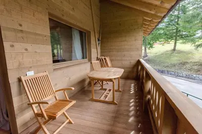 two chairs and a table on the porch of a cabin at Elegante Appartamento a Cortina in Cortina dʼAmpezzo