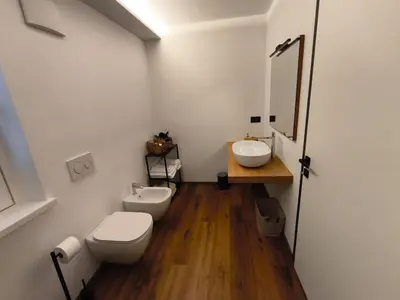 a bathroom with two sinks and a toilet and a mirror at Nemus Alpine Living in Cavalese