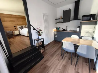 a dining room and kitchen with a table and chairs at Nemus Alpine Living in Cavalese
