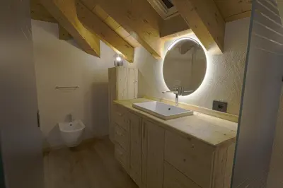 a bathroom with a sink and a mirror at Sky Loft at Cervo - Panoramic Penthouse in Moena in Moena