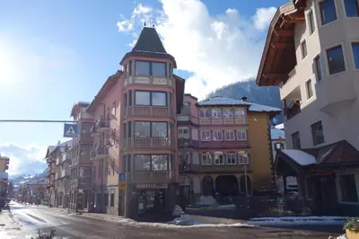 a tall building with a tower on a street at Sky Loft at Cervo - Panoramic Penthouse in Moena in Moena