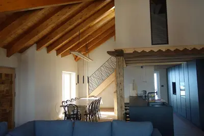 a living room with a blue couch and a table at Sky Loft at Cervo - Panoramic Penthouse in Moena in Moena