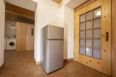 a kitchen with a refrigerator in the middle of a room at Apartments Romy in Ortisei