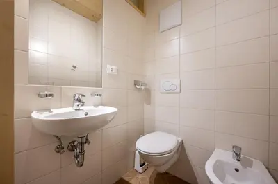 a bathroom with a toilet and a sink at Apartments Romy in Ortisei