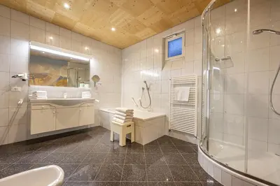 a bathroom with a tub and a sink and a shower at Apartments Romy in Ortisei