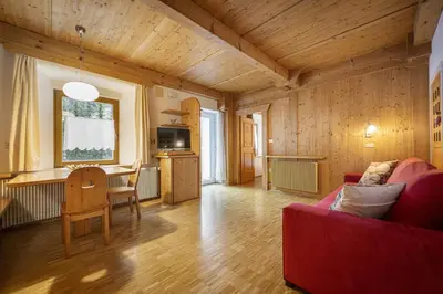 a living room with a red couch and a table at Apartments Romy in Ortisei