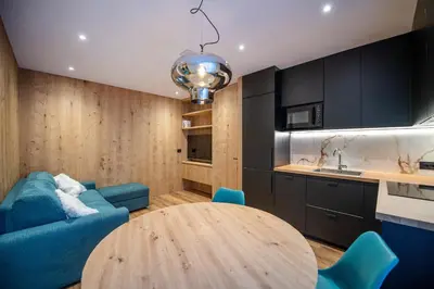 a living room with a blue couch and a table at Tito Apartments in Ortisei
