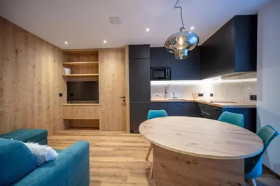 a kitchen and dining room with a wooden table at Tito Apartments in Ortisei