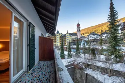 a balcony with a view of a snowy town at Tito Apartments in Ortisei