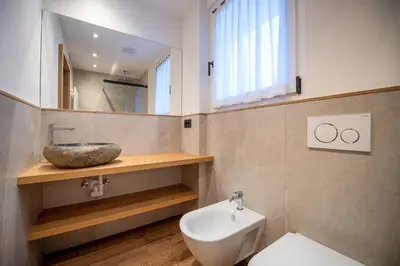 a bathroom with a sink and a toilet at Tito Apartments in Ortisei