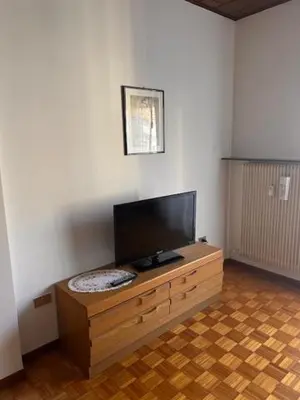 a living room with a flat screen tv on a wooden cabinet at Casa Iris in Laives