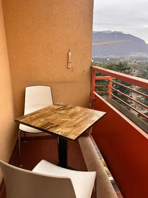 a wooden table and two chairs on a balcony at Casa Iris in Laives