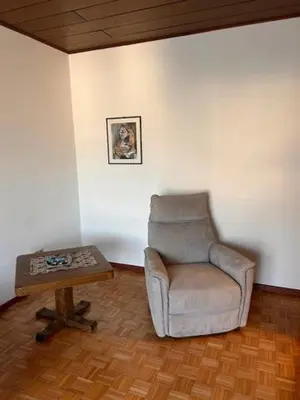 a living room with a chair and a coffee table at Casa Iris in Laives