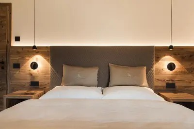 a bedroom with a bed in a room with a mirror at Ciasa Bel Marin in La Villa