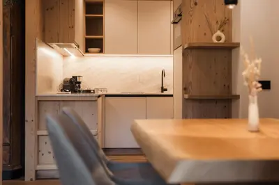a kitchen with a table and chairs in a room at Ciasa Bel Marin in La Villa