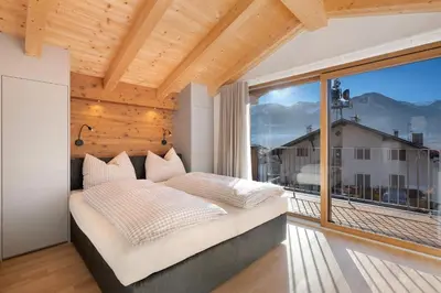a bedroom with a bed and a large window at Villa Helena in Cavalese