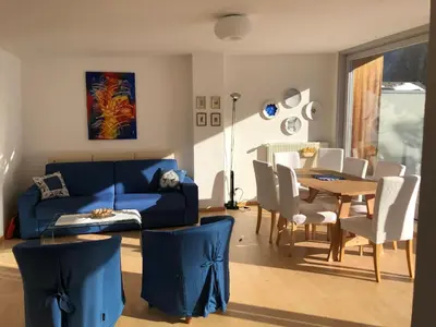 a living room with a blue couch and a table at Appartamento panoramico vicino al Kronplatz in Riscone