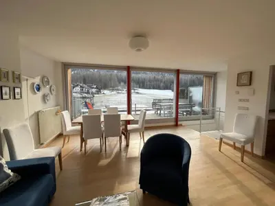 a living room with a table and chairs at Appartamento panoramico vicino al Kronplatz in Riscone