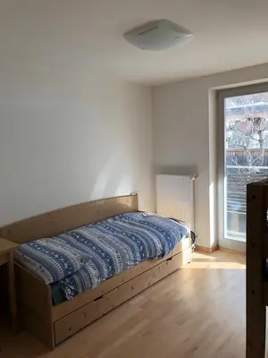 a bedroom with a bed and a large window at Appartamento panoramico vicino al Kronplatz in Riscone