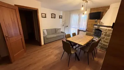 a small bedroom with a white bed and wooden walls at Flowery House Canazei - Val di Fassa in Canazei