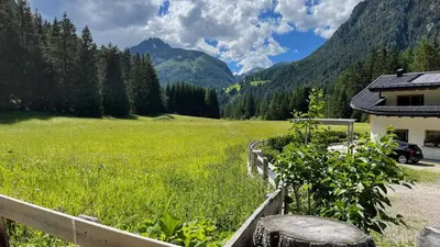 a bedroom with a bed with a pair of shoes on it at Flowery House Canazei - Val di Fassa in Canazei