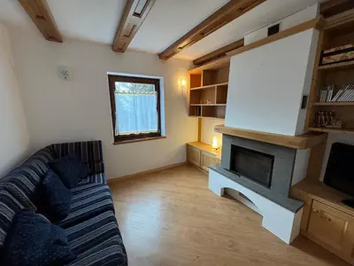 a living room with a couch and a fireplace at Villetta rifugio tra i larici in Varena