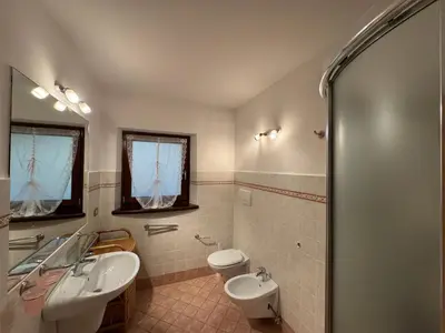 a bathroom with two sinks and a toilet at Villetta rifugio tra i larici in Varena