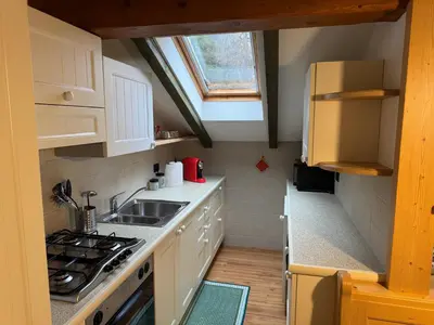a small kitchen with a sink and a stove at Villetta rifugio tra i larici in Varena