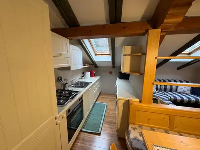 a kitchen with white cabinets and a stove top oven at Villetta rifugio tra i larici in Varena