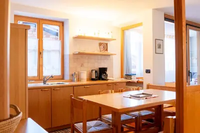 a kitchen with a wooden table and a table and chairs at Casa Rita Brenta - Ruffrè-Mendola in Ronzone