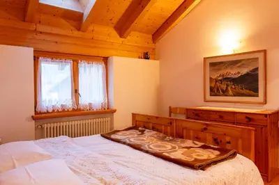 a bedroom with a bed with a wooden ceiling at Casa Rita Brenta - Ruffrè-Mendola in Ronzone