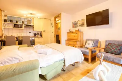 a bedroom with a bed and a living room at Chalet Salejada - WiFi comfort and elegance in Moena
