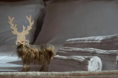 a stuffed reindeer on a bed with towels at Chalet Salejada - WiFi comfort and elegance in Moena