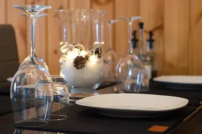 a table with wine glasses and a plate on it at Chalet Salejada - WiFi comfort and elegance in Moena